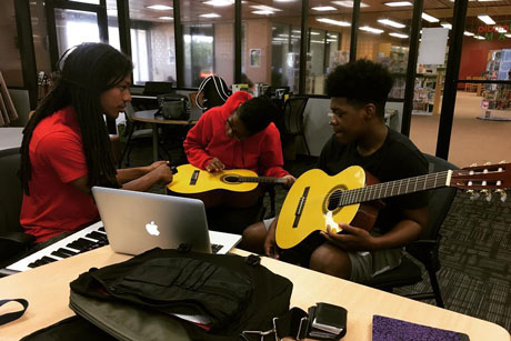 Mentor teaching teens to play classical guitar